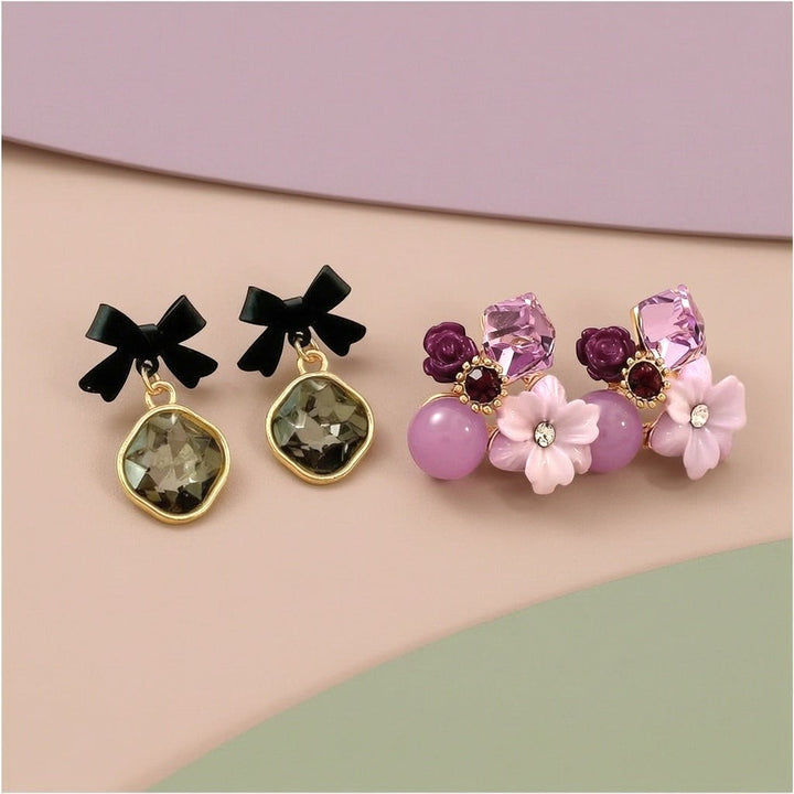 dazzle21 set of two earrings featuring black bow studs with grey crystals and purple floral rhinestone clusters