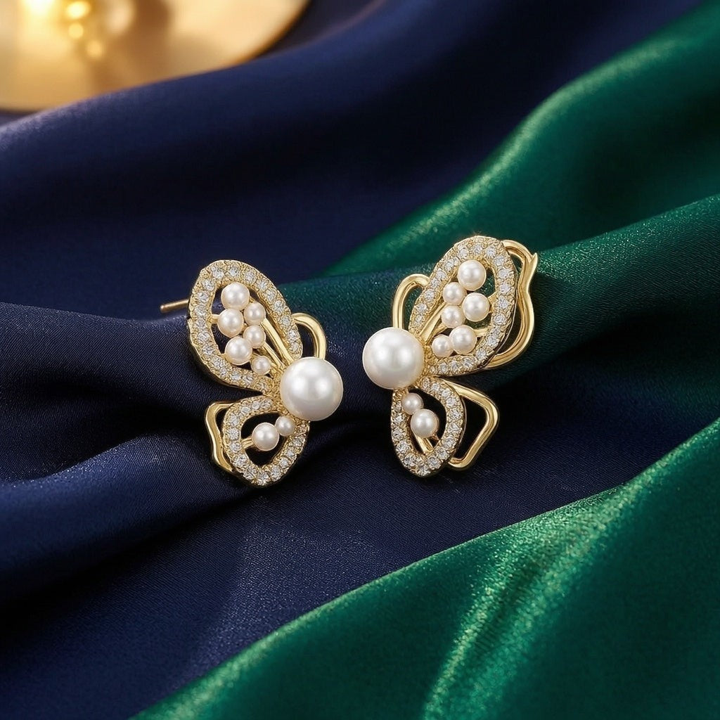 dazzle21 butterfly-shaped earrings featuring white pearls and sparkling crystals set in gold-tone metal
