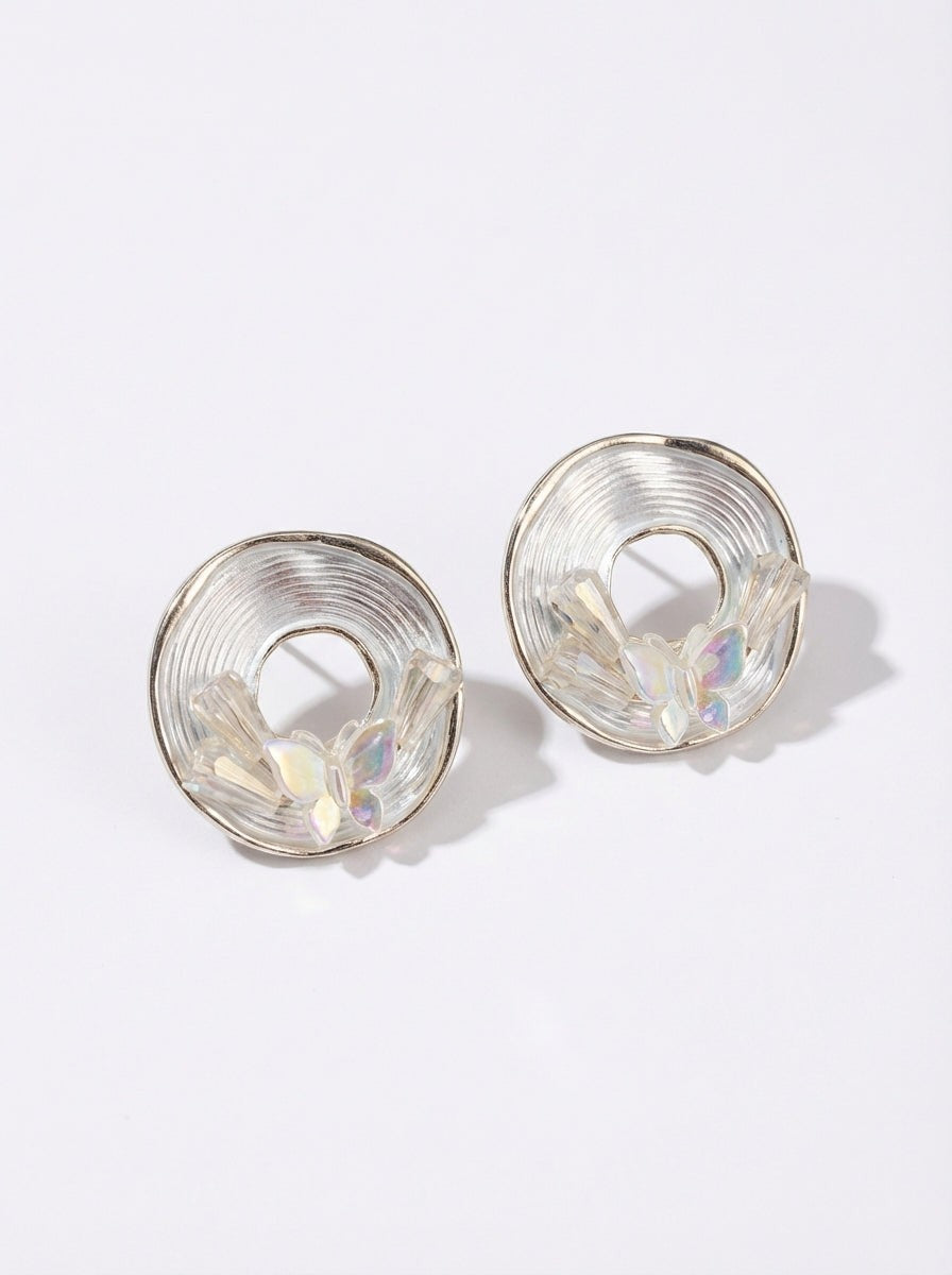 dazzle21 Blossom Glow stud earrings featuring a circular spiral design with delicate pastel butterfly accents.