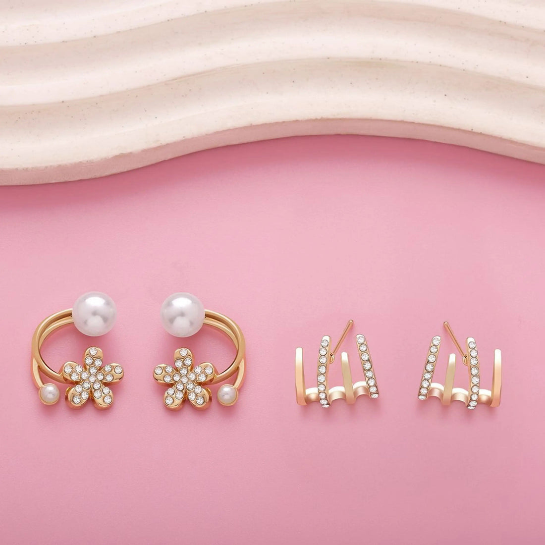 dazzle21 gold-tone daisy flower earrings with faux pearls and crystal studs on a pink background