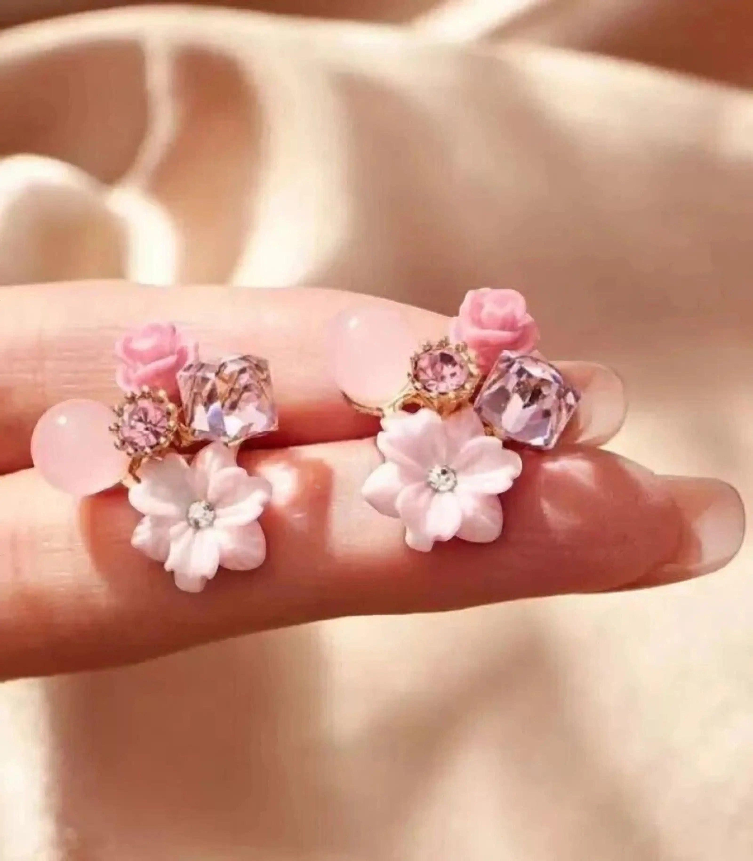 dazzle21 Korean designer stud earrings featuring pink floral accents, clear crystals, and soft rose details on gold tone