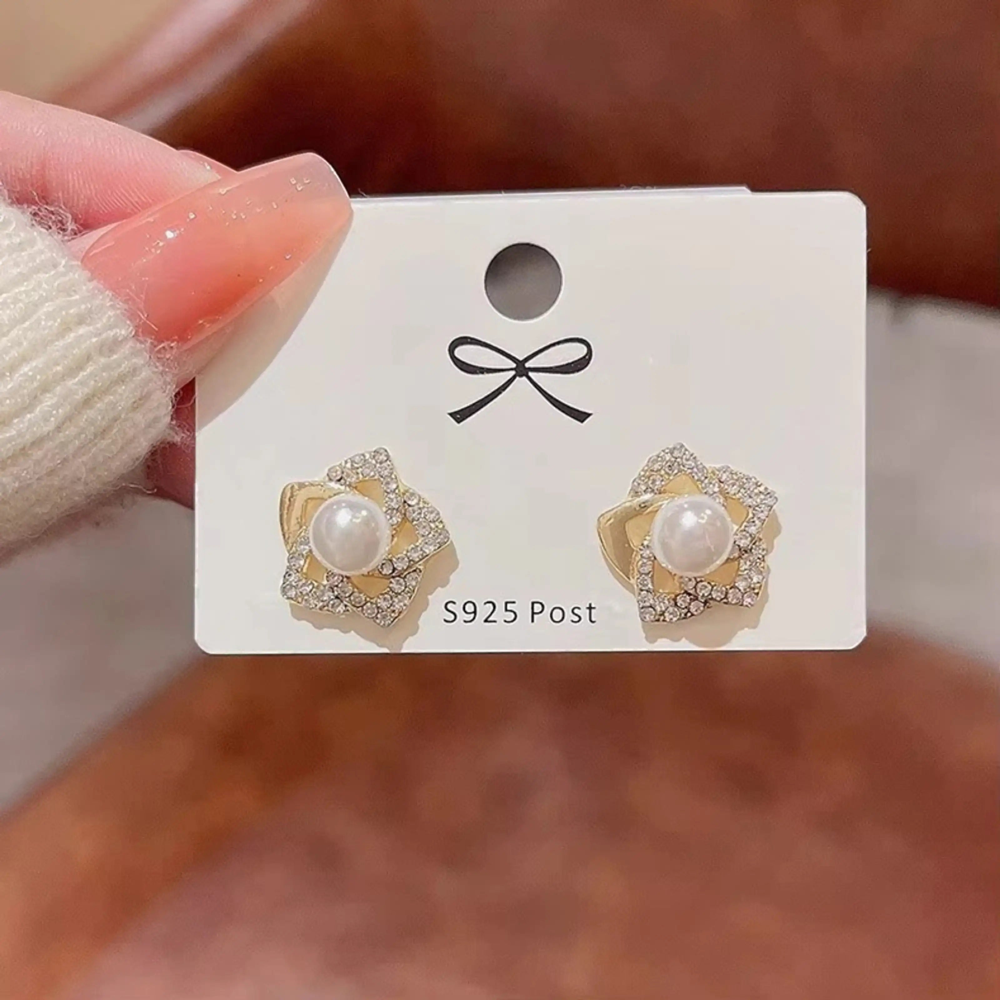 dazzle21 gold-tone flower stud earrings with central faux pearls and sparkling rhinestones on an S925 post card