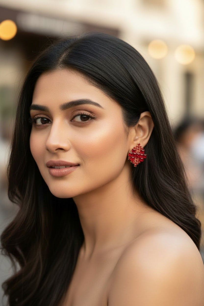 dazzle21 Royal geometric stud earrings with red crystals and rose gold finish worn by a woman