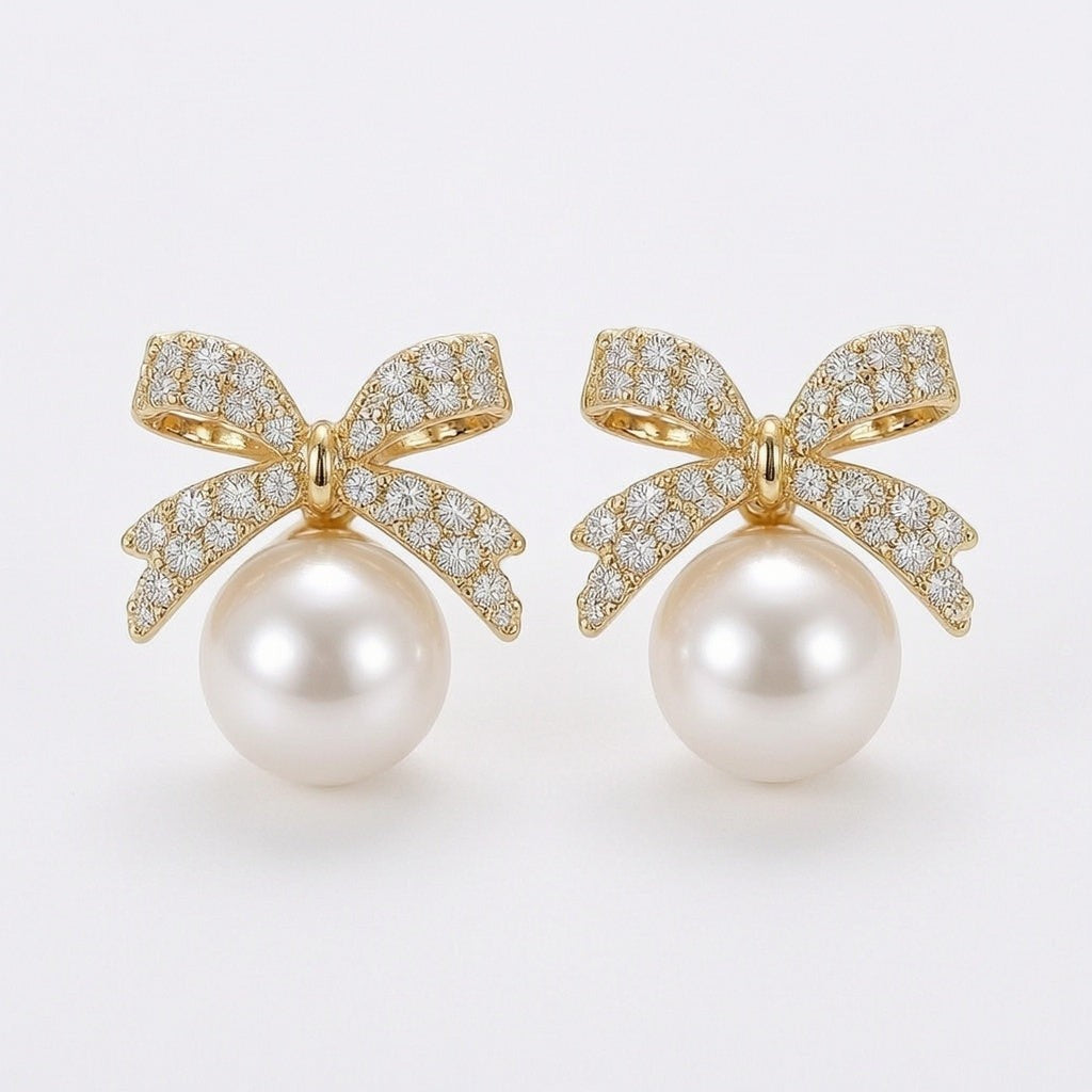 dazzle21 gold bow stud earrings featuring sparkling rhinestones and a dangling white pearl drop