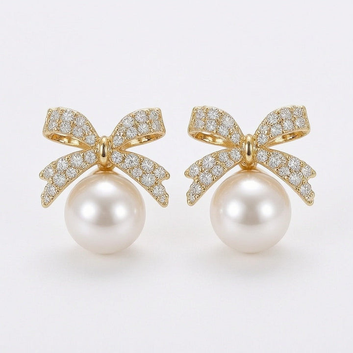 dazzle21 gold bow stud earrings featuring sparkling rhinestones and a dangling white pearl drop