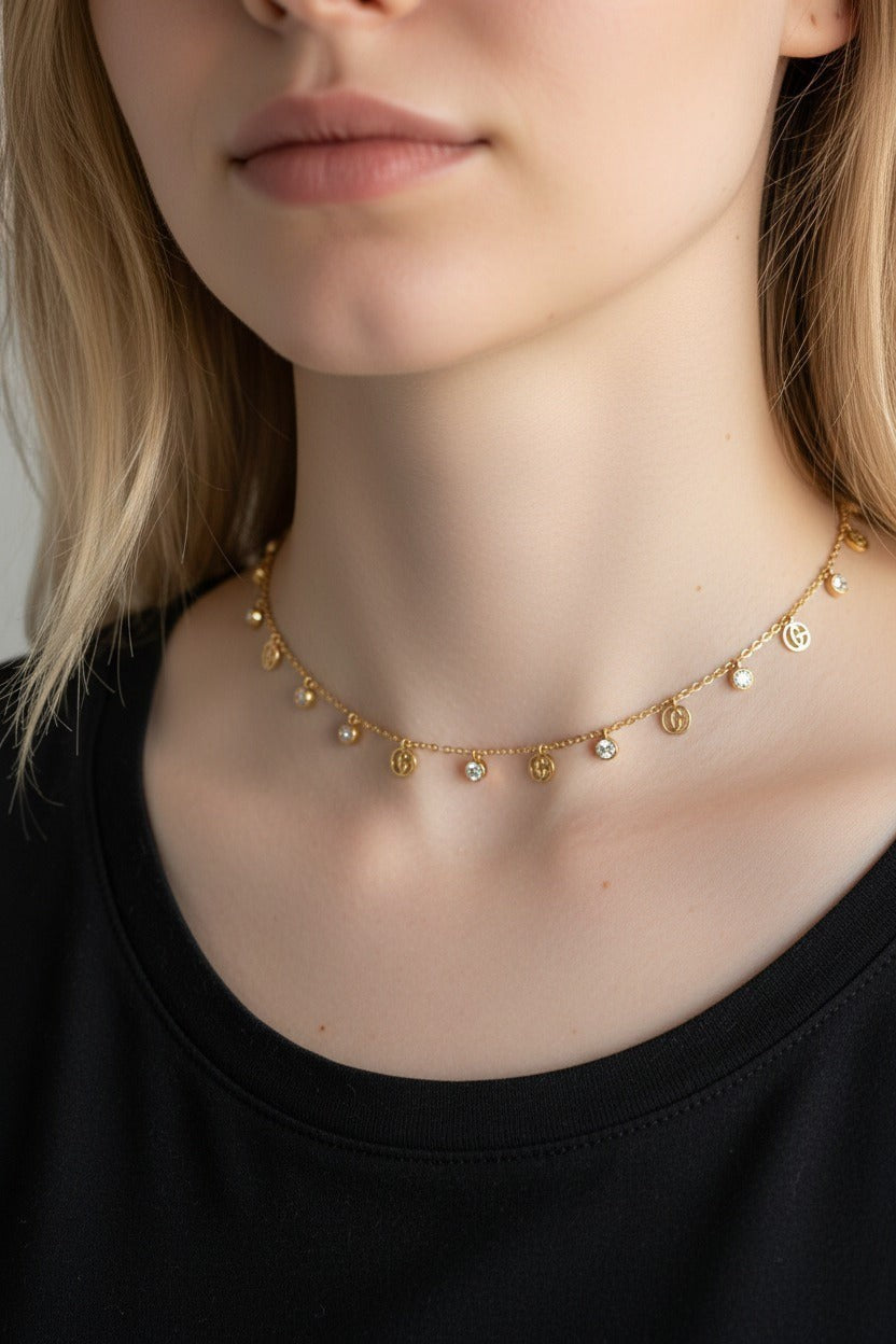 dazzle21 gold charm necklace with delicate circular pendants and crystals worn by a woman in a black top