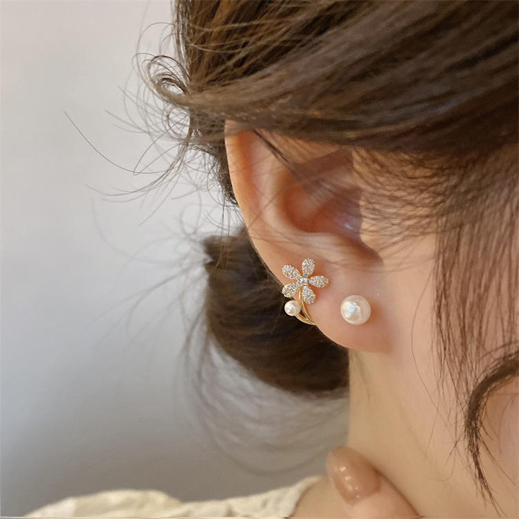 dazzle21 gold daisy ear jacket earrings with micro-crystals and faux pearls worn on a woman's ear