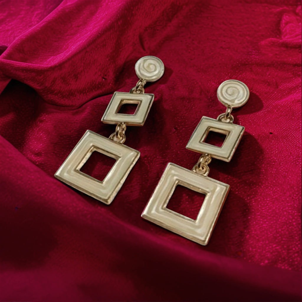 dazzle21 gold-tone geometric double-square drop earrings resting on a rich red velvet fabric background