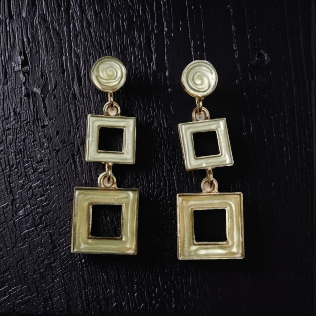 dazzle21 gold-tone geometric drop earrings featuring a modern double-square design on a textured black background