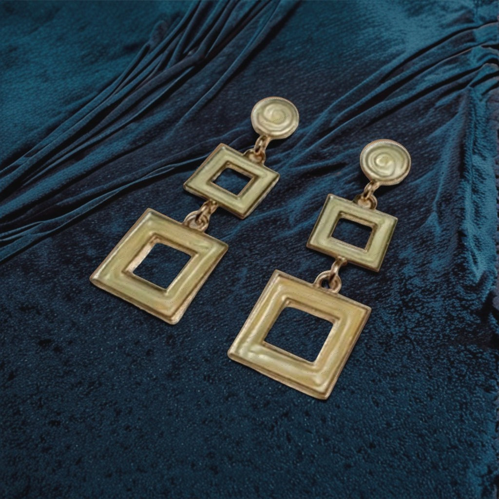 dazzle21 gold-tone geometric double-square drop earrings resting on a dark blue velvet fabric background
