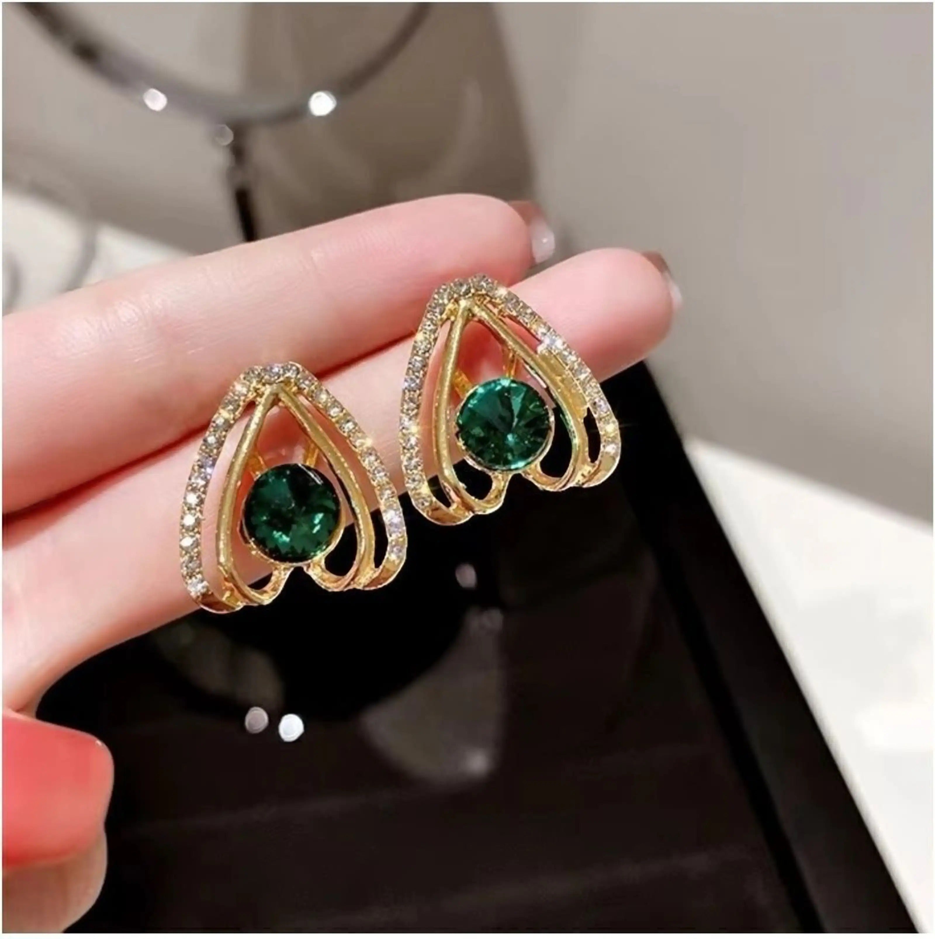 dazzle21 gold stud earrings featuring a heart-shaped frame with a central green crystal and sparkling rhinestones