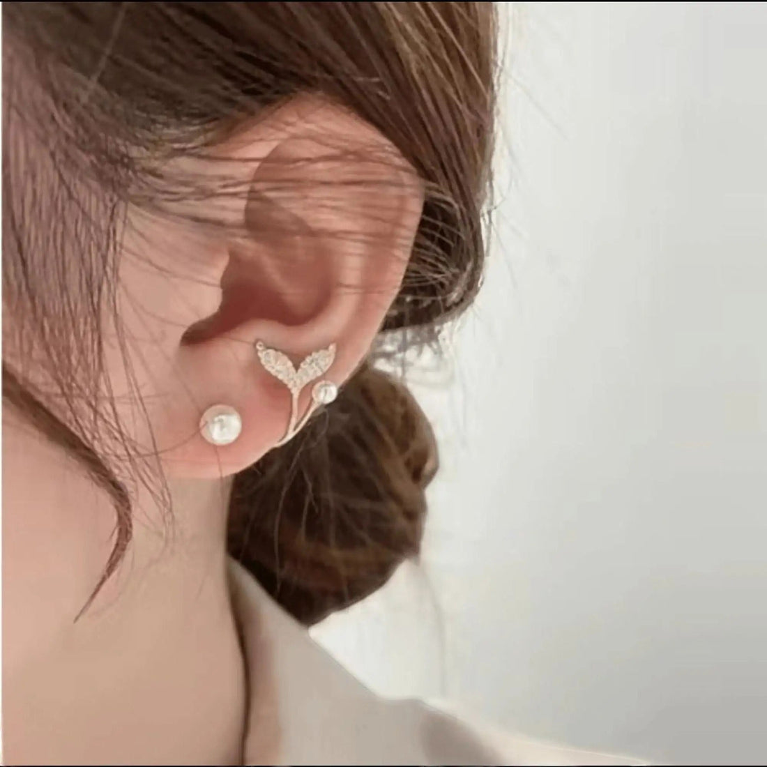 dazzle21 gold plated leaf and pearl stud earring set worn on earlobe with cubic zirconia accents