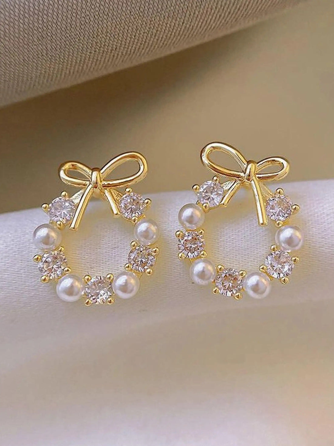 dazzle21 gold-tone bow earrings featuring a wreath design with alternating white pearls and sparkling crystal stones