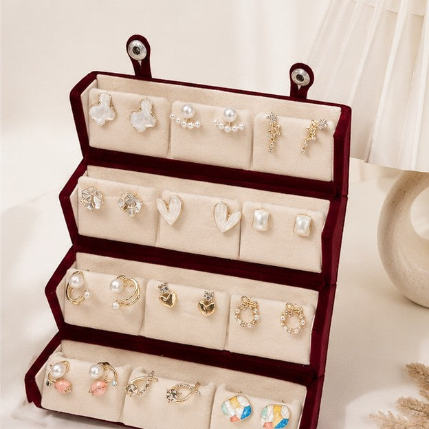 dazzle21 12-pair fashion earring set featuring gold-tone studs, hoops, and pearl accents in a velvet display box