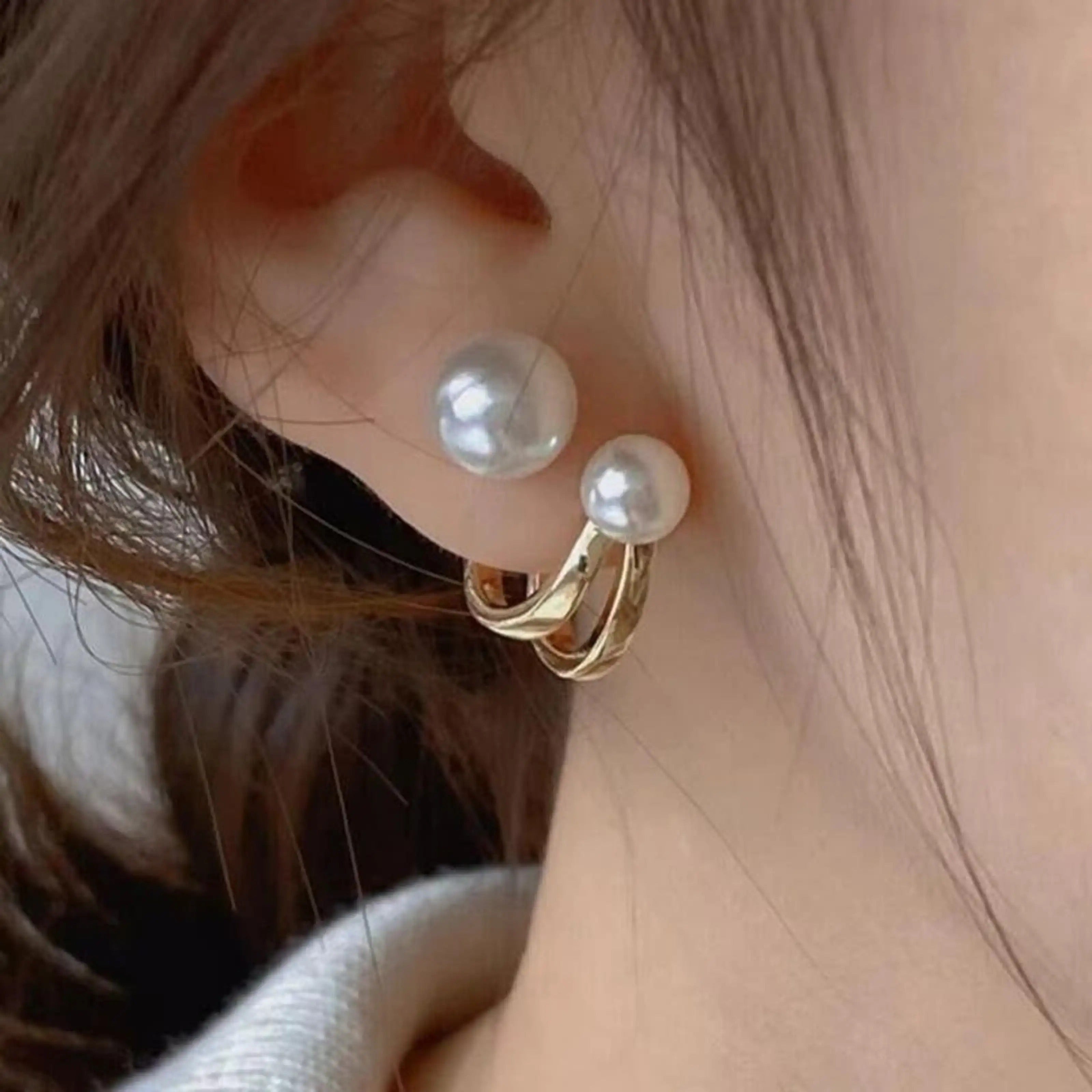 dazzle21 gold hoop earrings with white pearl studs worn on an ear for a stylish and elegant look