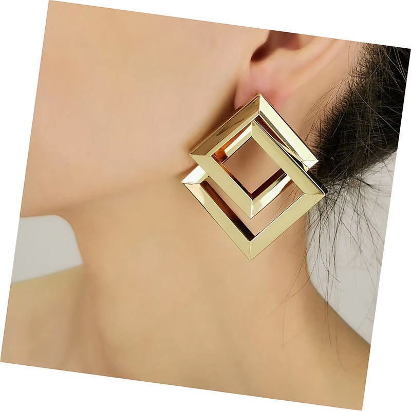 dazzle21 geometric square statement earrings in a polished gold-tone finish worn on a model