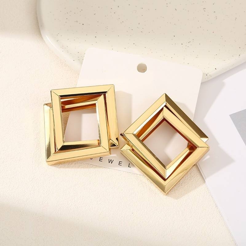 dazzle21 geometric square statement earrings in polished gold-tone metal with a layered open-frame design.