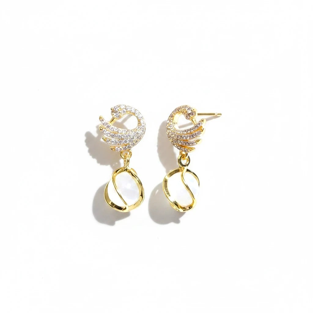 dazzle21 gold swan dangle earrings with shimmering stones and luminous white orb drops on a white background