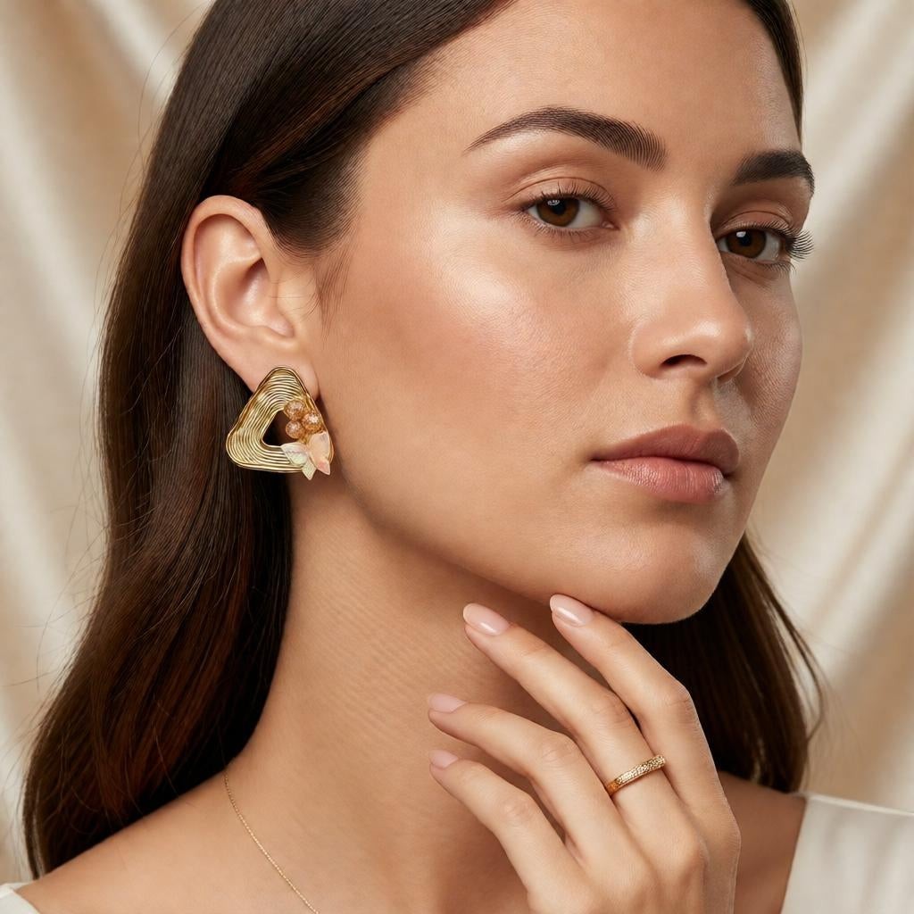 dazzle21 geometric gold triangle stud earrings with peach pearls and iridescent butterfly accents worn by a model
