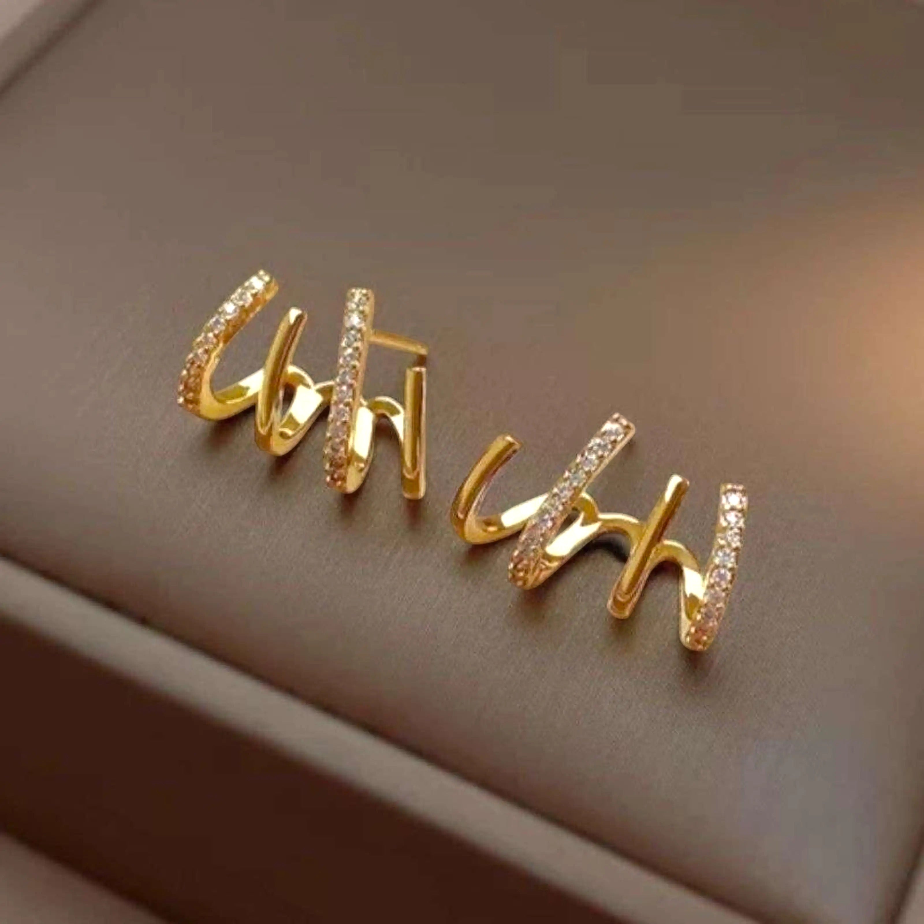 dazzle21 gold-toned alloy stud earrings with a multi-prong claw design and sparkling zirconia accents