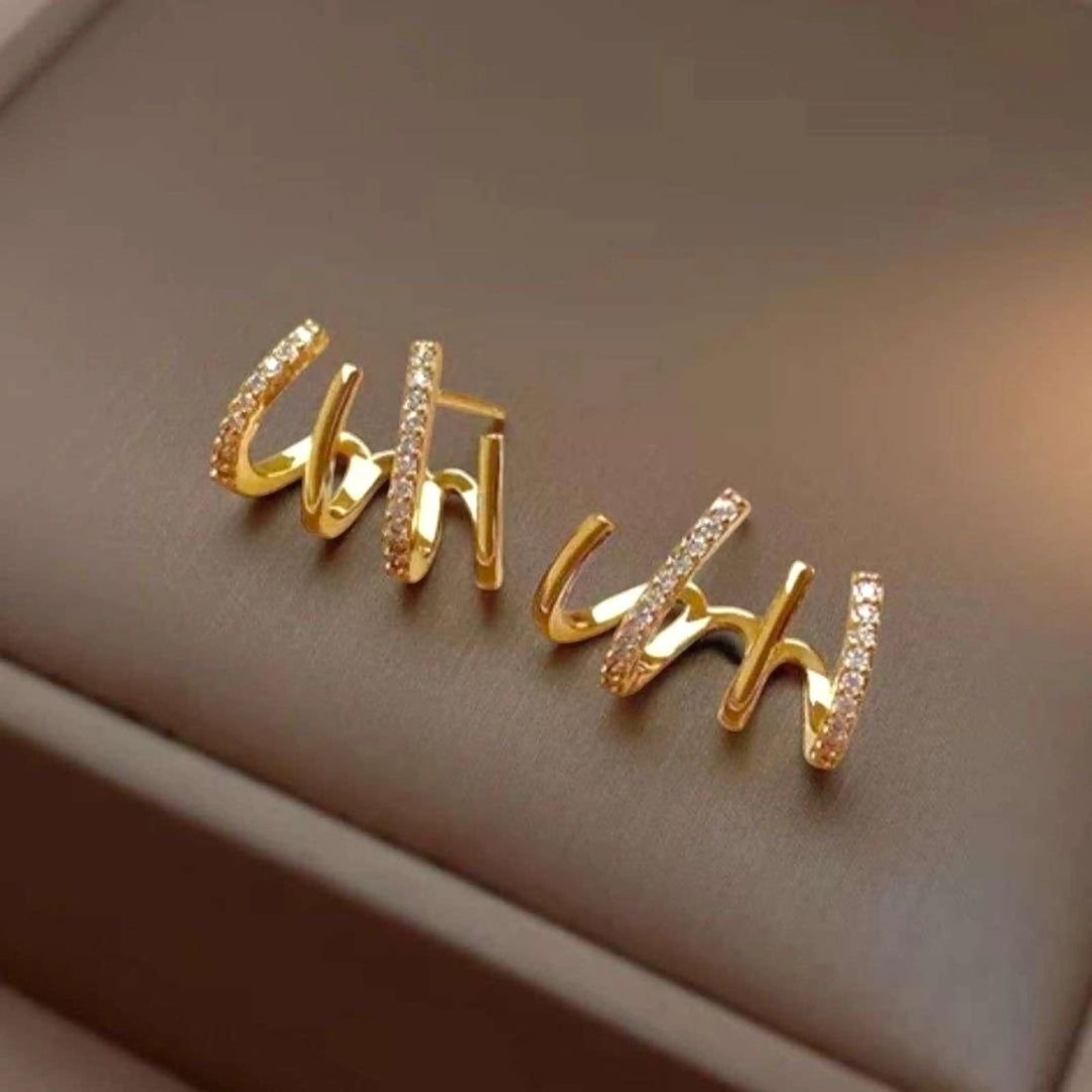 dazzle21 gold-toned alloy stud earrings with a multi-prong claw design and sparkling zirconia accents