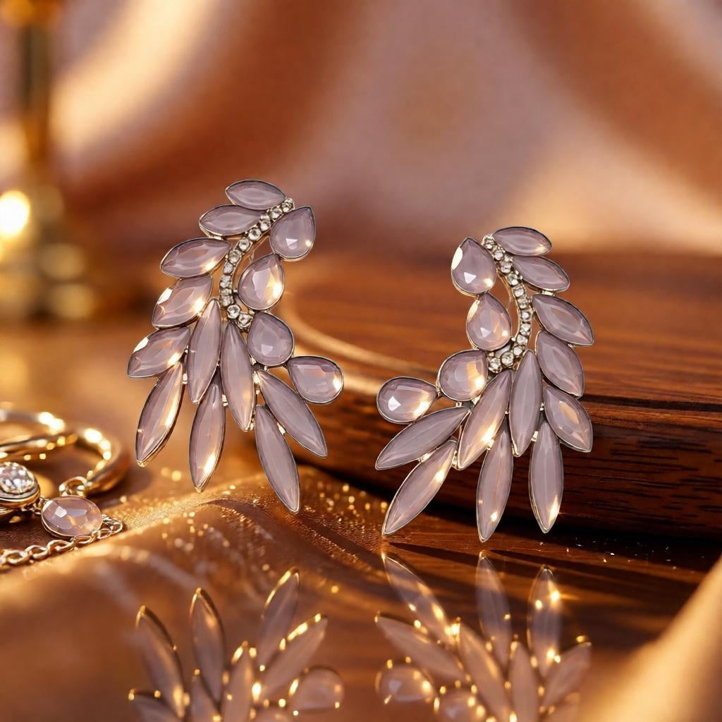 dazzle21 golden leaf-shaped statement stud earrings with shimmering crystal accents on a reflective surface