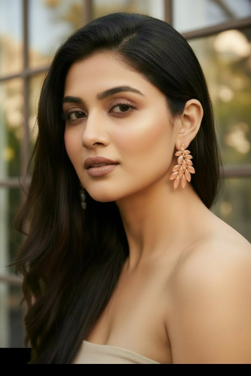 dazzle21 golden leaf-shaped stud earrings with crystal accents worn by a woman with long dark hair
