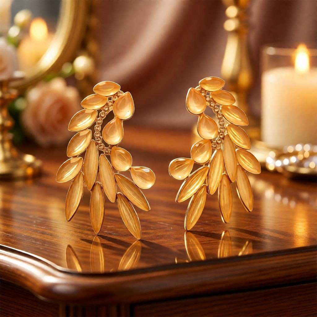 dazzle21 golden leaf-shaped statement stud earrings with crystal accents on a polished wooden surface