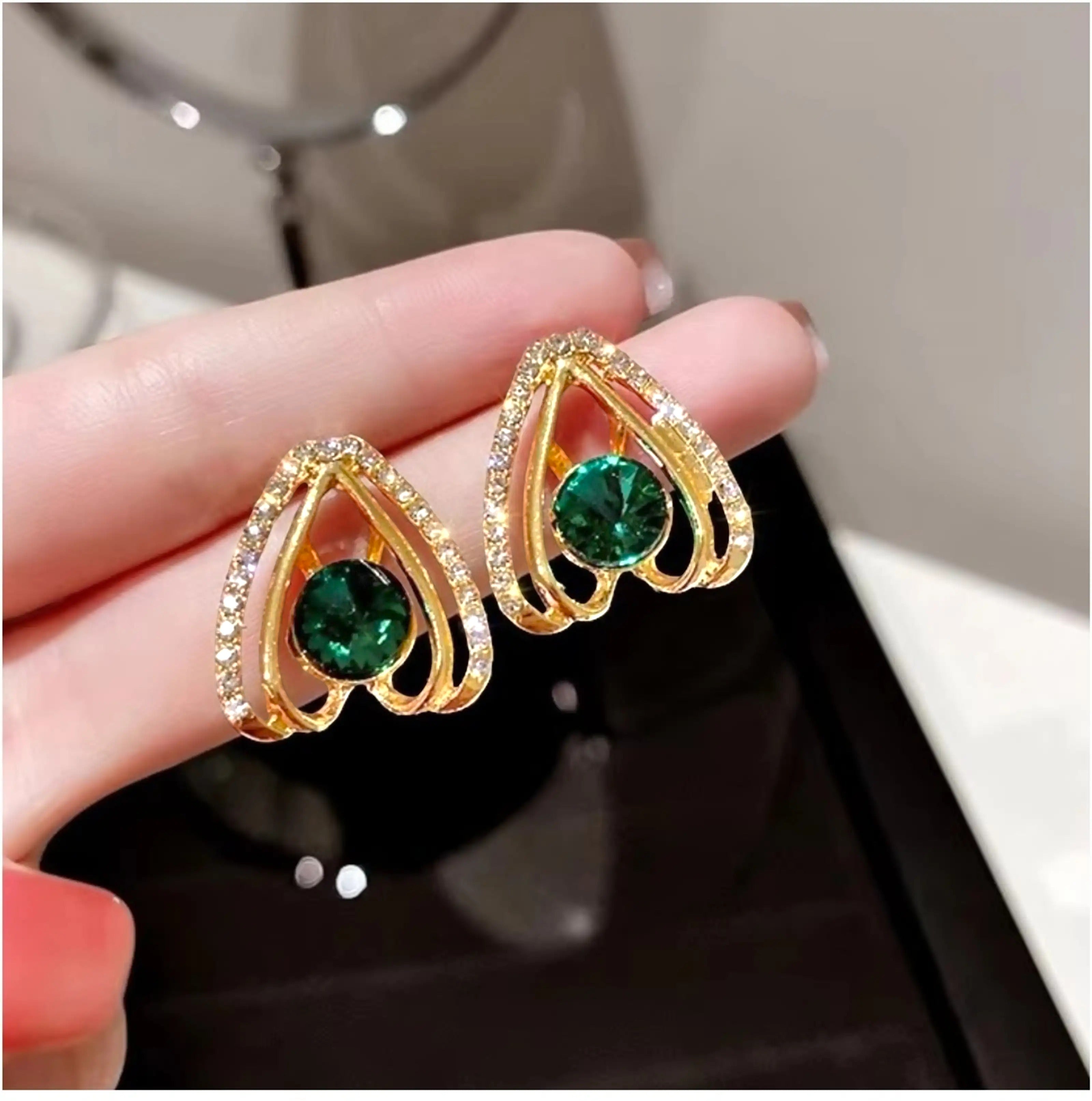 dazzle21 gold-tone statement stud earrings featuring a central green crystal surrounded by clear rhinestones