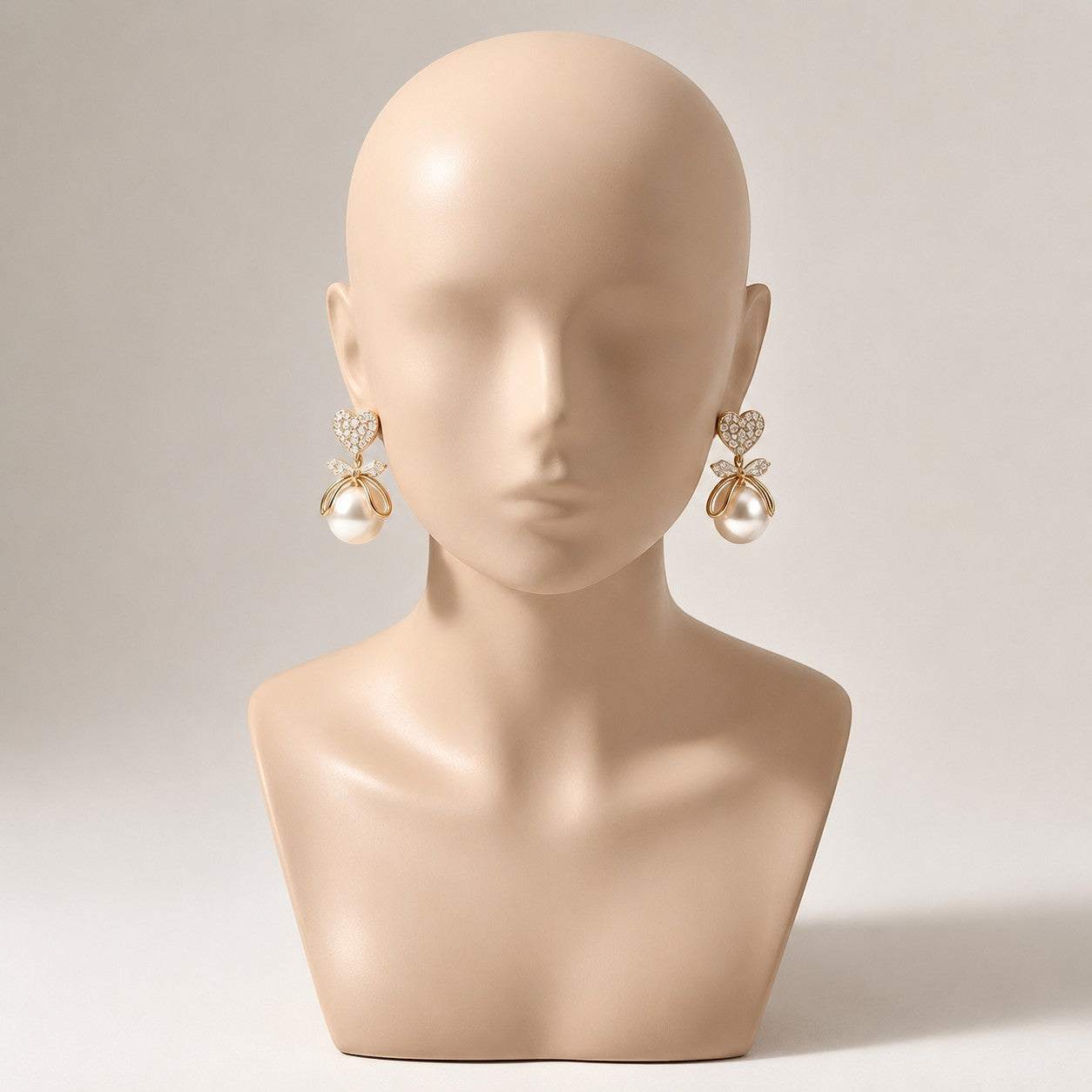 dazzle21 gold-tone heart-shaped pearl earrings with crystal accents on a mannequin bust