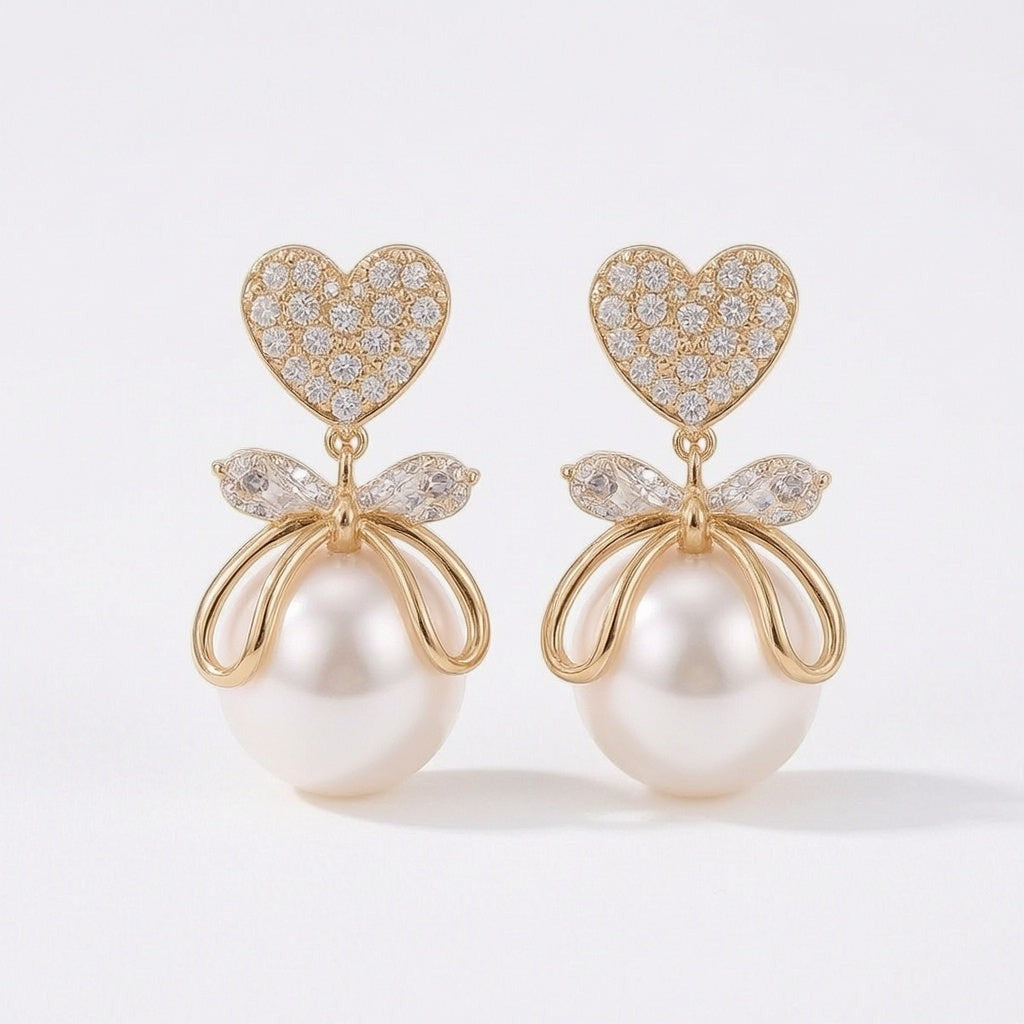 dazzle21 gold-tone heart-shaped crystal stud earrings with a bow accent and dangling white pearl drop
