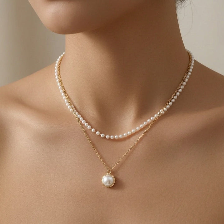 dazzle21 layered necklace featuring a delicate pearl strand and a gold chain with a single pearl pendant
