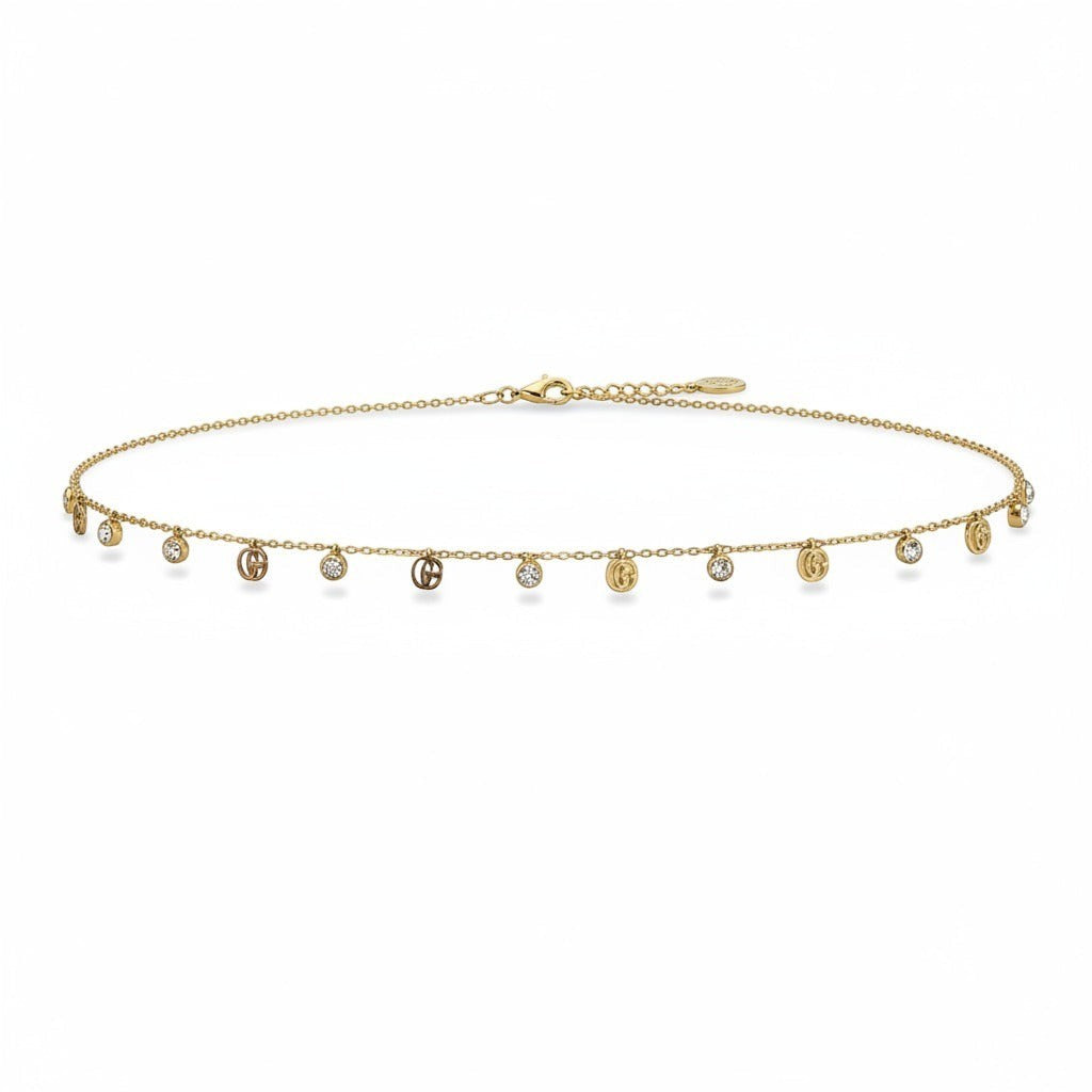 dazzle21 minimalist gold anklet featuring delicate chain with alternating crystal and logo charms for elegant wear