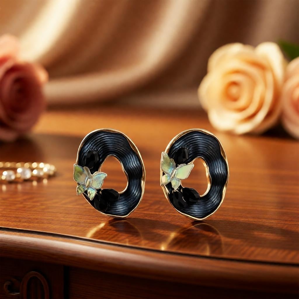 dazzle21 oval stud earrings featuring iridescent butterfly motifs, black textured centers, and gold-tone frames.