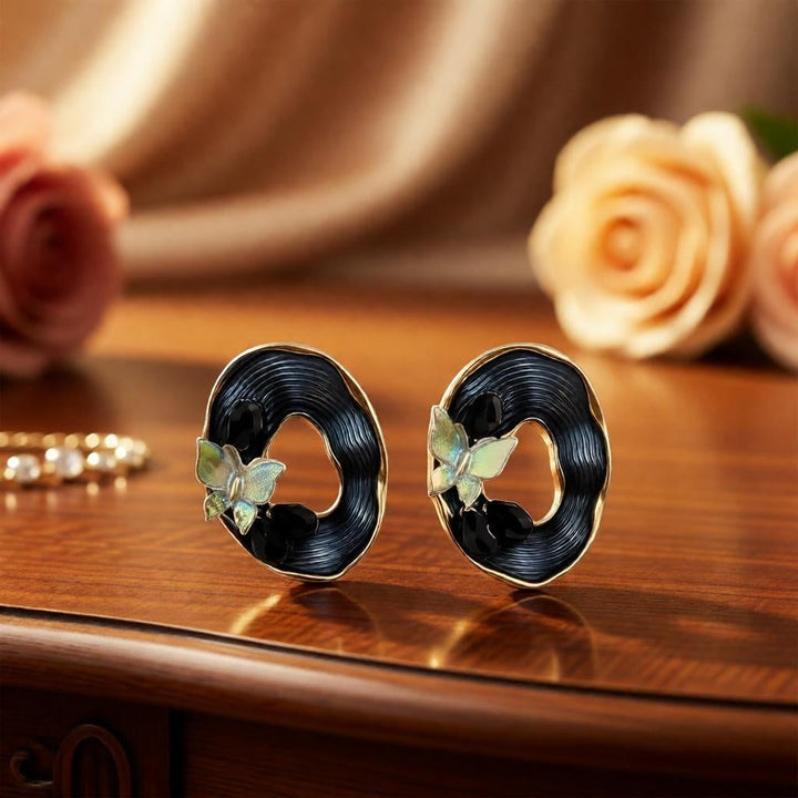 dazzle21 oval stud earrings featuring iridescent butterfly motifs, black textured centers, and gold-tone frames.