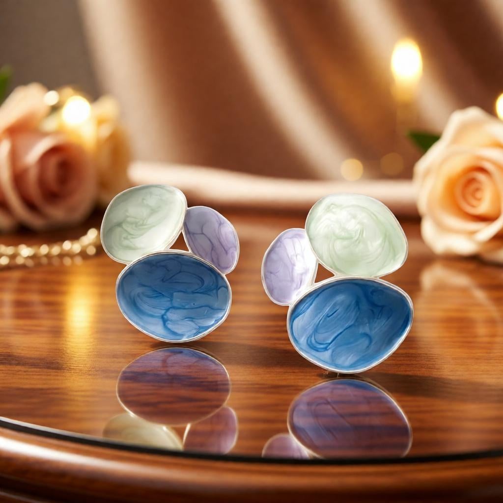 dazzle21 pastel statement earrings with blue, mint green, and lavender marble resin swirls on a wooden table