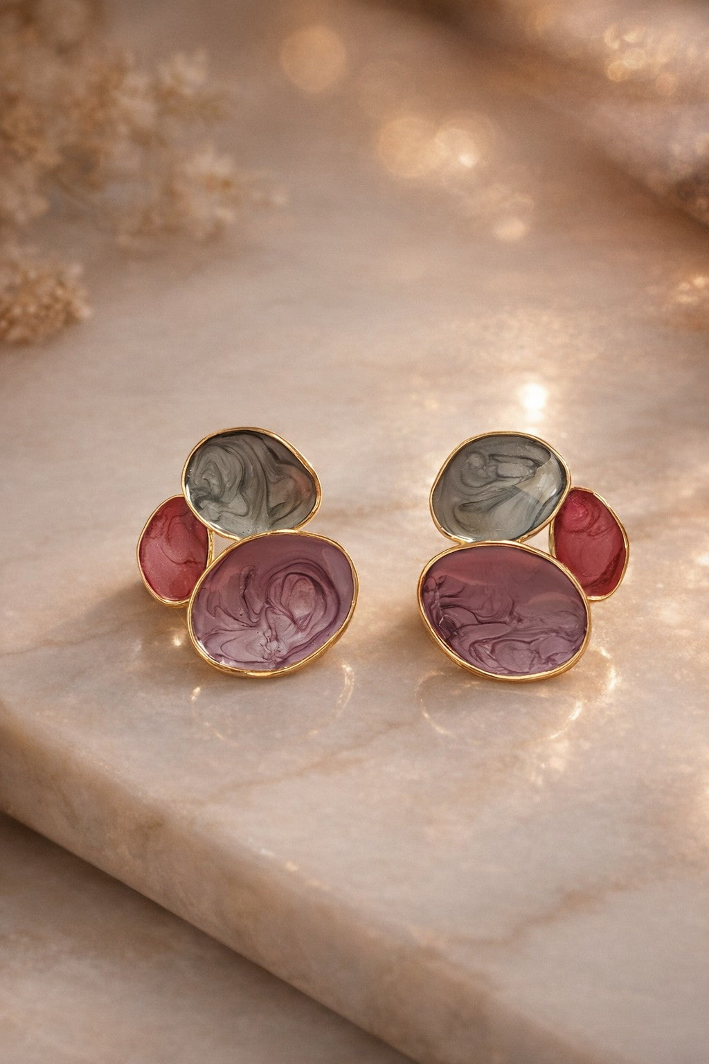 dazzle21 handcrafted pastel statement earrings with marble-effect resin in blue, pink, and lavender on a marble surface