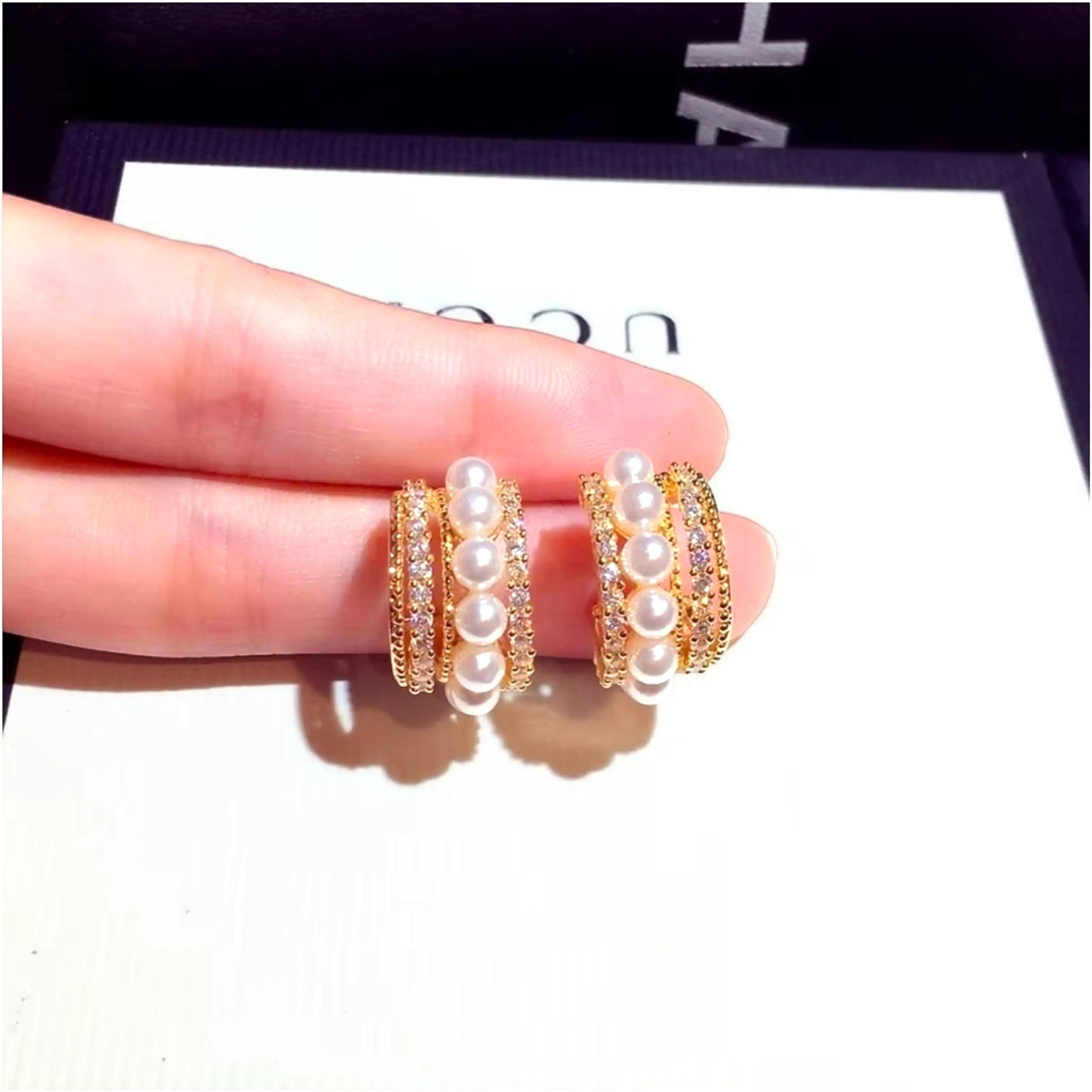 dazzle21 gold-toned half hoop earrings featuring rows of white pearls and sparkling cubic zirconia crystals
