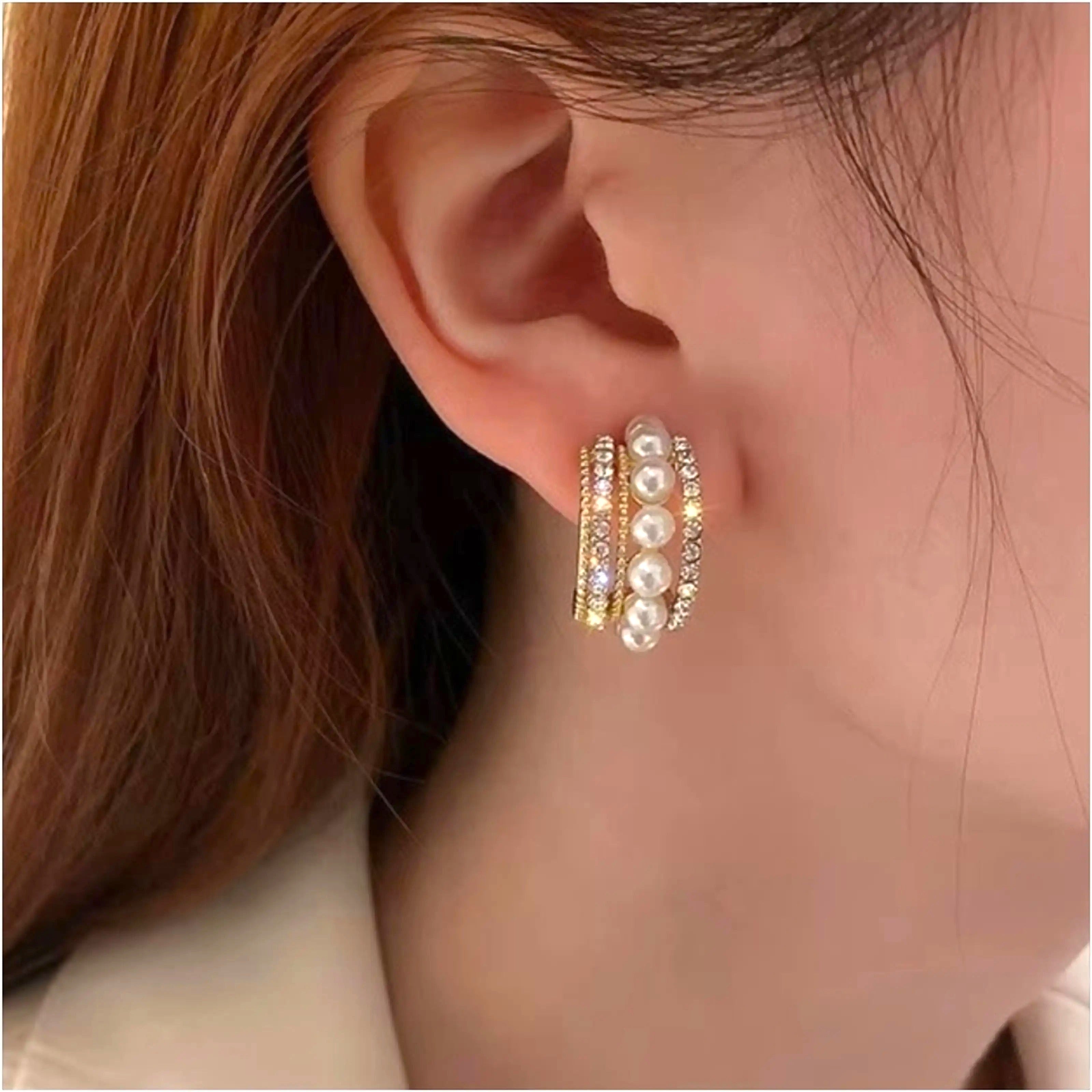 dazzle21 gold-tone half hoop earrings featuring a row of white pearls flanked by sparkling cubic zirconia crystals