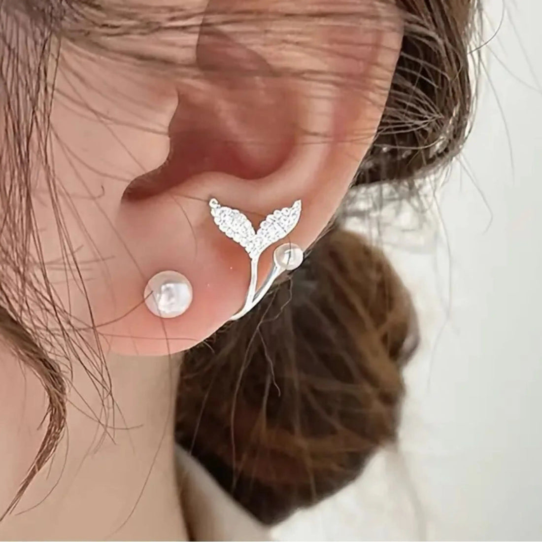 dazzle21 alloy stud earrings featuring a pearl and a crystal-encrusted mermaid tail design worn on an earlobe