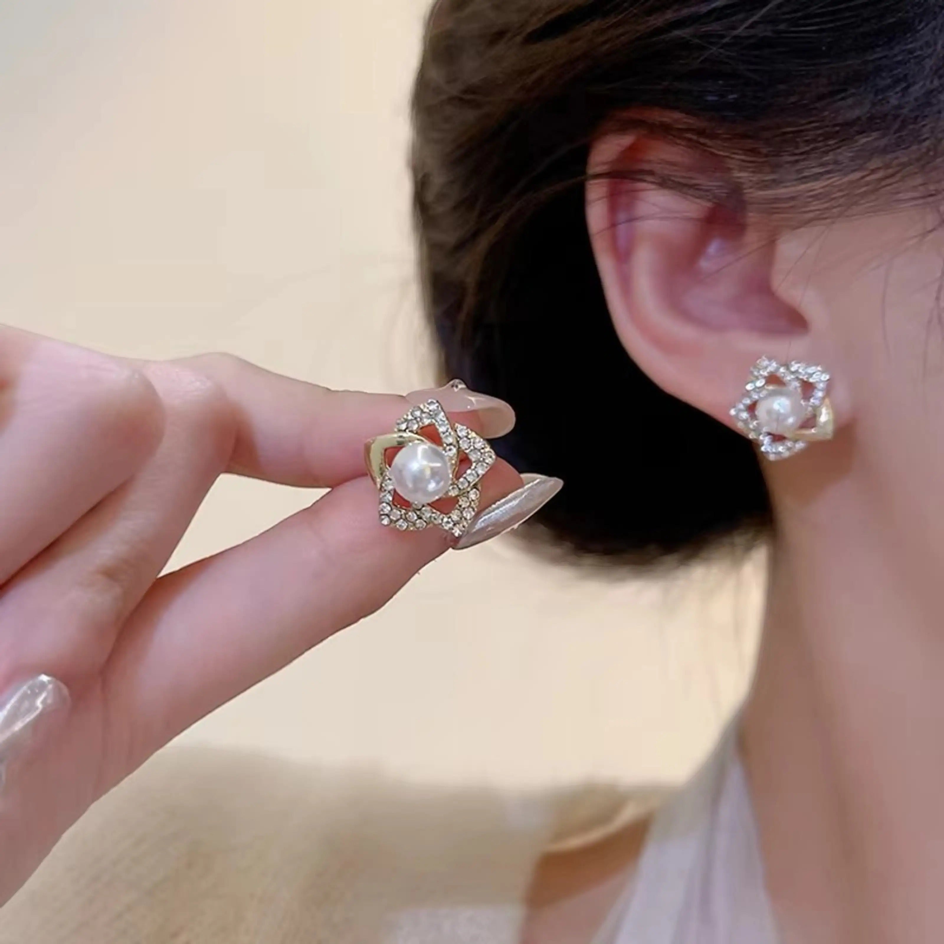 dazzle21 star-shaped stud earrings featuring a central pearl surrounded by sparkling cubic zirconia crystals