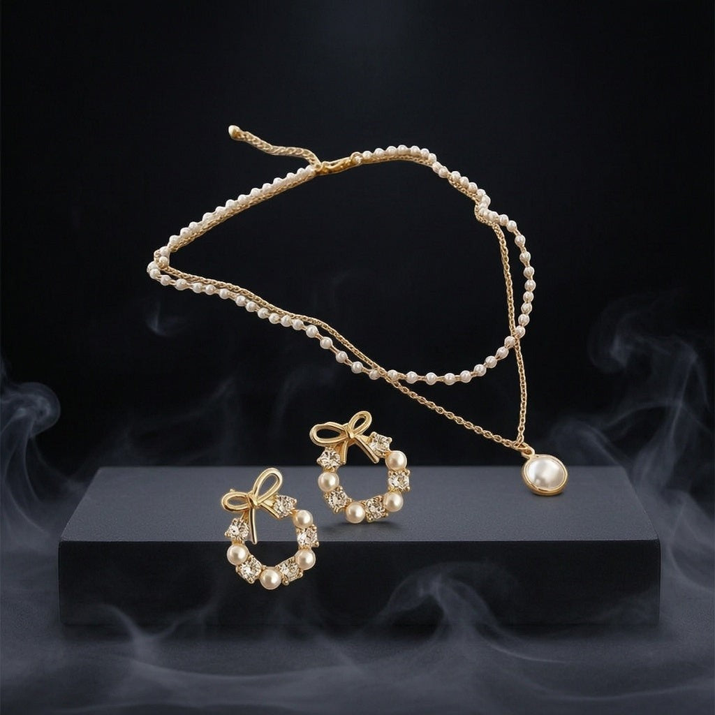 dazzle21 gold-tone pearl necklace and bow-shaped pearl stud earring set on a black display stand