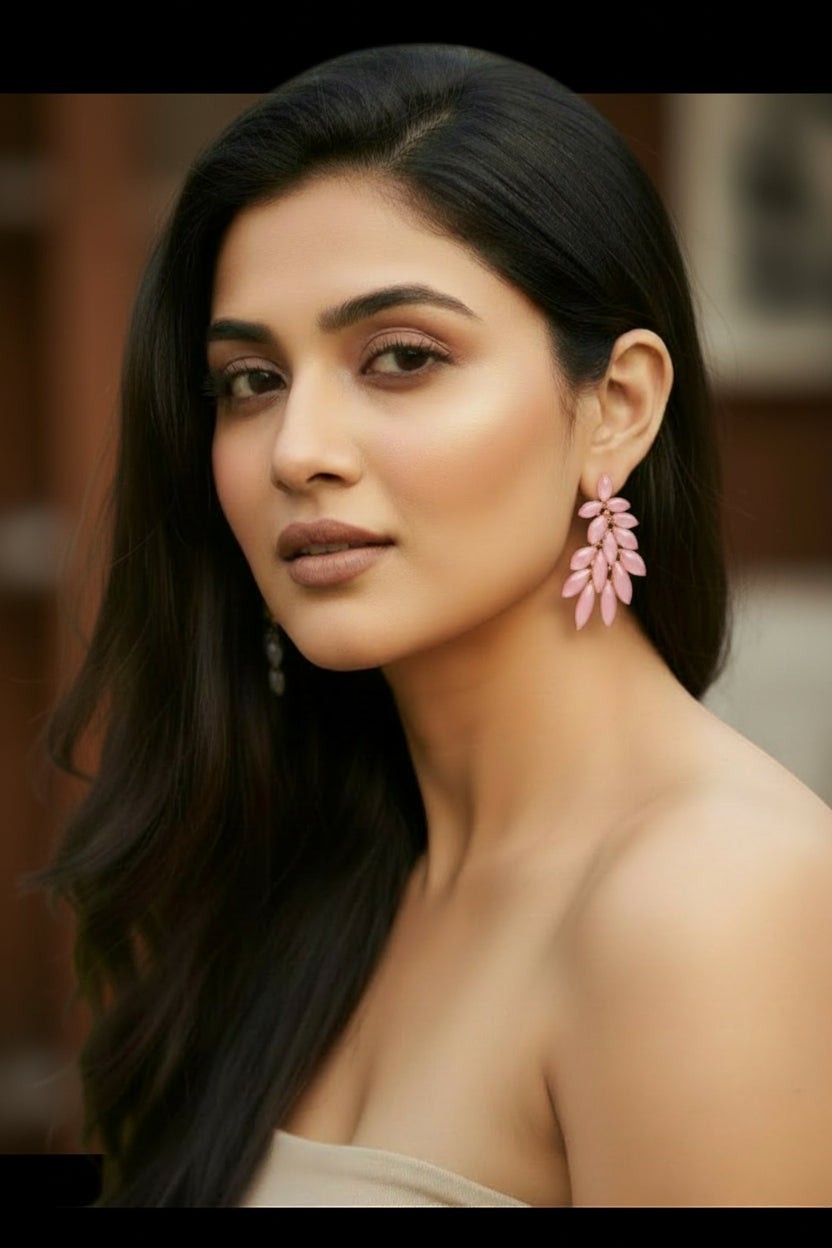 A model wearing pink leaf-shaped statement stud earrings from dazzle21, featuring a delicate crystal design.