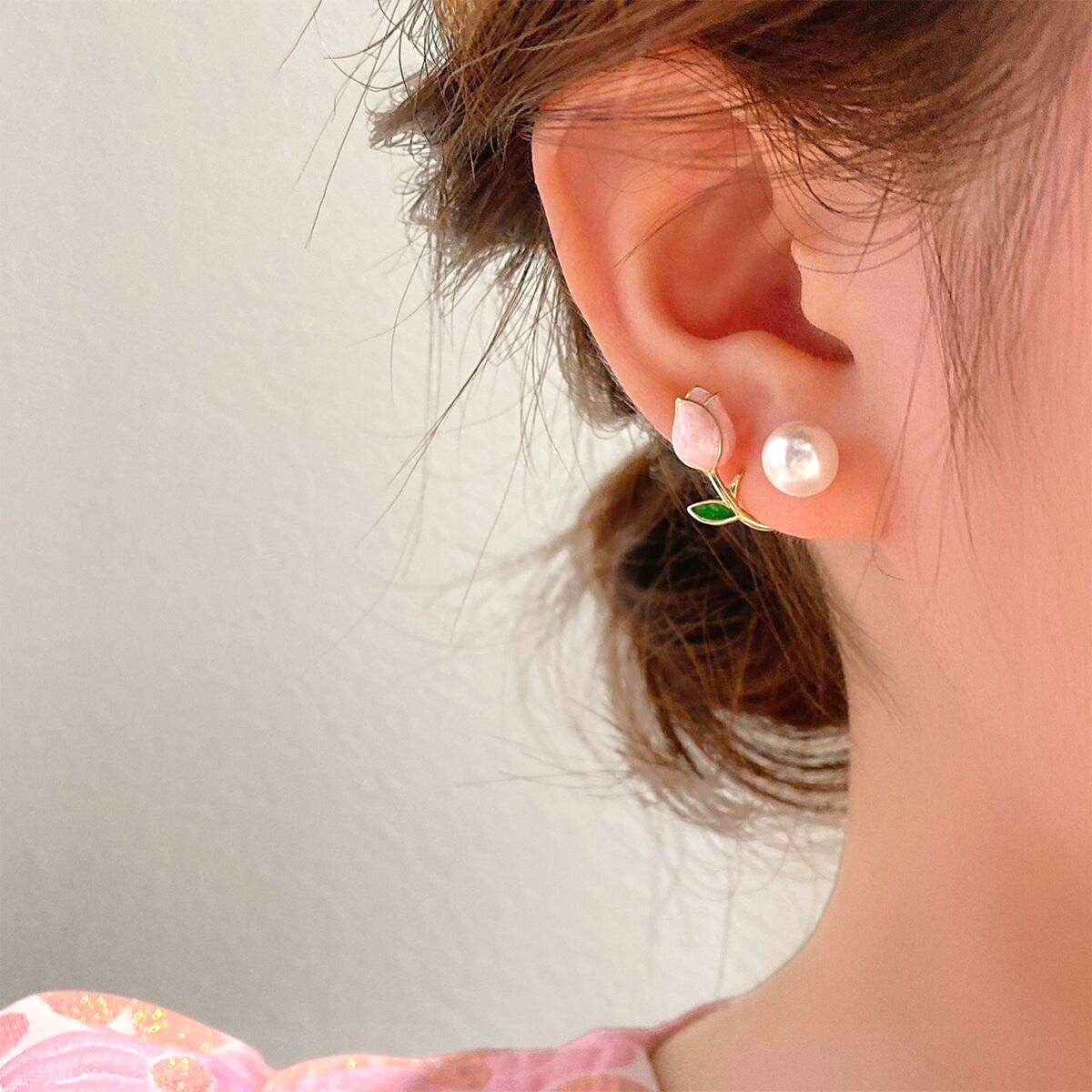 dazzle21 gold-tone ear cuff earrings featuring a pink tulip, green leaf, and faux pearl worn on a woman's ear