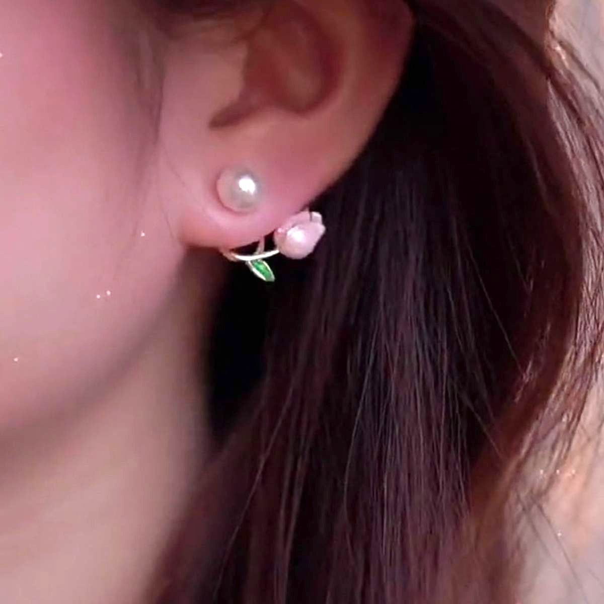 dazzle21 gold-tone ear cuff earrings featuring a pink tulip, green leaf, and faux pearl worn on a woman's ear