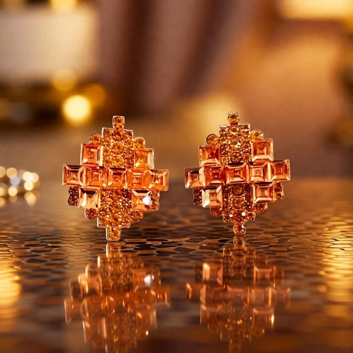 dazzle21 geometric stud earrings in rose gold with layered crystal stones on a reflective surface