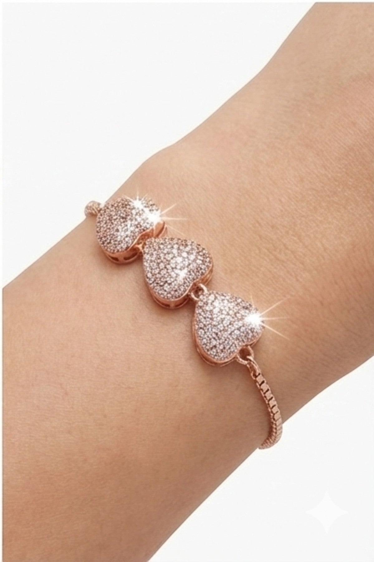 dazzle21 rose gold-tone triple heart bracelet with pavé crystal stones and an adjustable sliding bolo clasp on a wrist