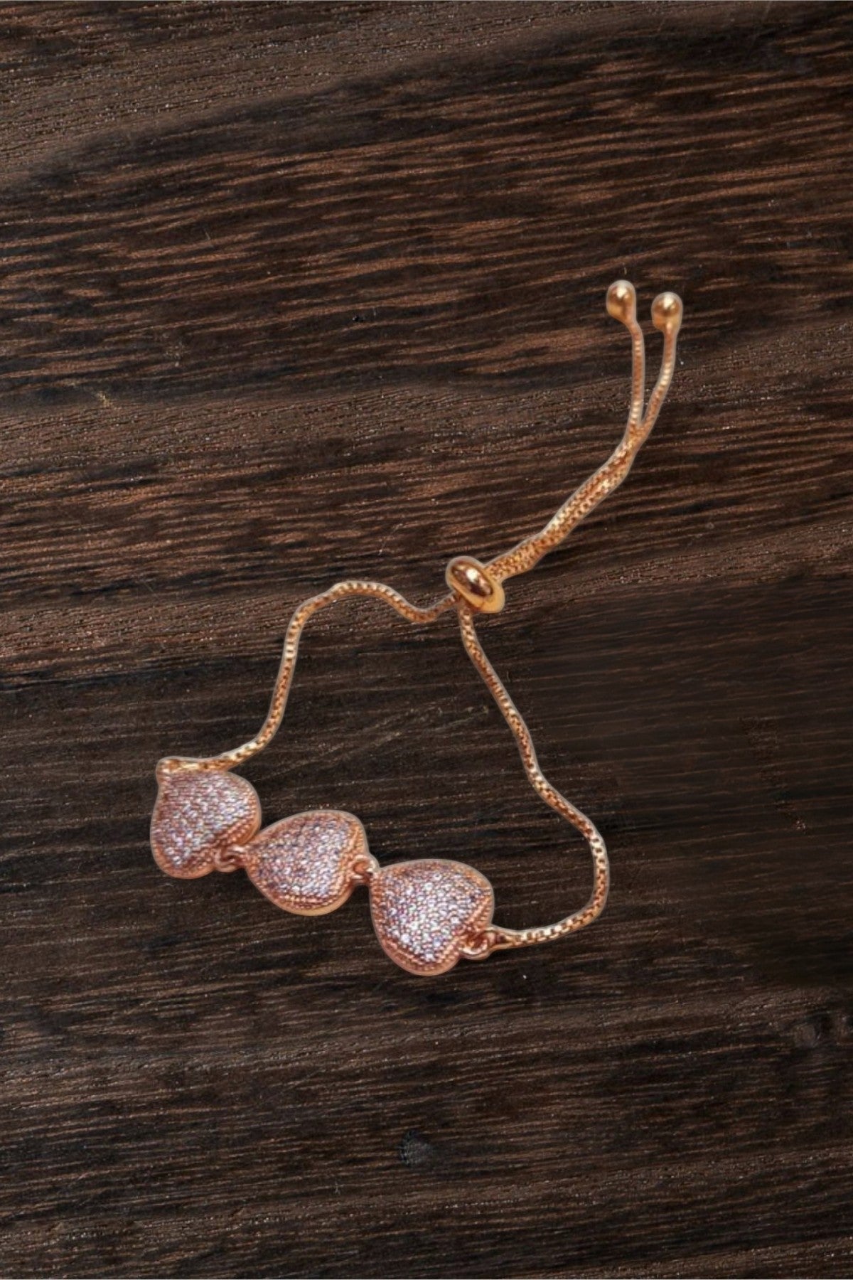 dazzle21 rose gold-tone triple heart bracelet with pavé crystal stones and an adjustable sliding bolo clasp