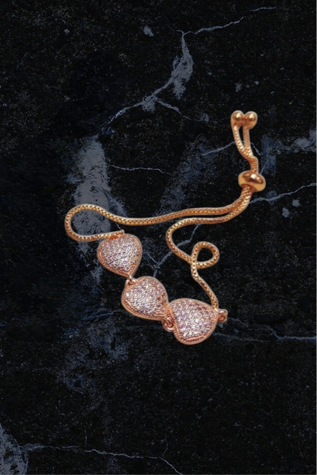 dazzle21 rose gold-tone triple heart bracelet with pavé crystal stones and an adjustable sliding bolo clasp